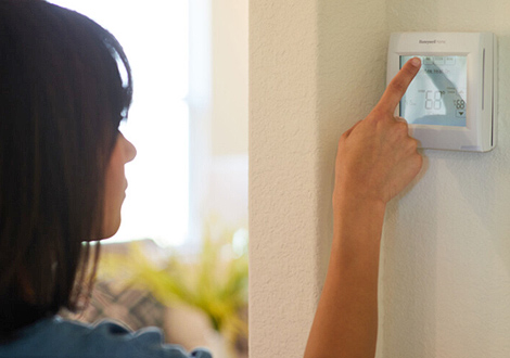 Woman Programming Energy-Efficient Thermostat